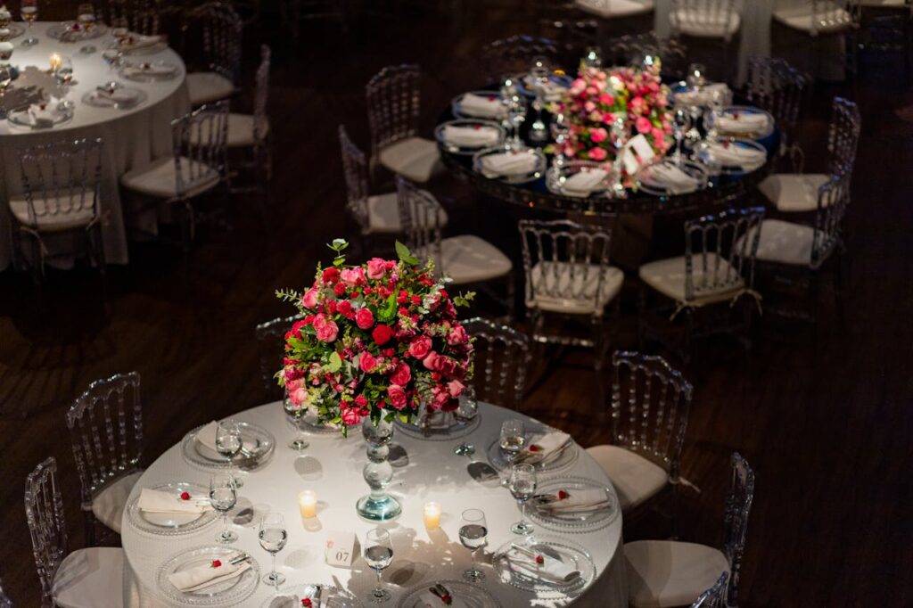 Beautifully decorated wedding reception tables with floral centerpieces and candles, creating an elegant ambiance.