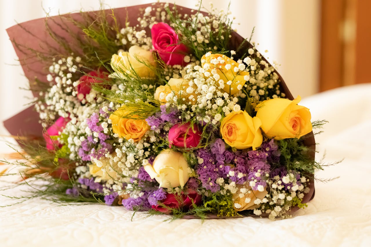 A vibrant bouquet featuring yellow and pink roses with baby's breath, ideal for celebrations.
