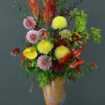 A colorful floral arrangement showcasing various flowers in an ornate vase.