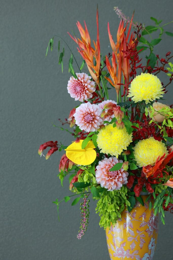 Vibrant floral arrangement in a decorative vase against a neutral background.