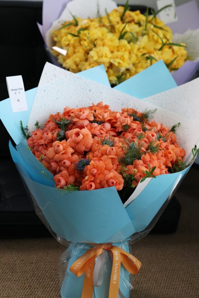 Vibrant orange and yellow flower bouquets elegantly wrapped with decorative ribbon.